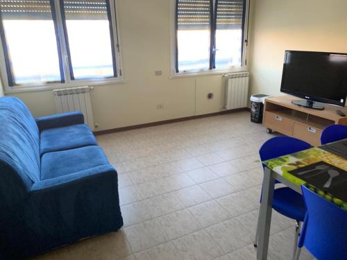 salon z niebieską kanapą i telewizorem w obiekcie Bicocca Flat A w Mediolanie
