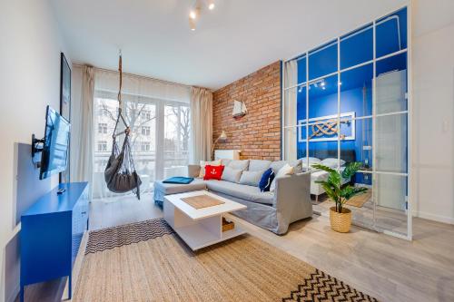 sala de estar con paredes azules y sofá en Apartamenty Sun & Snow Riverfront Gdańsk, en Gdansk