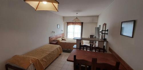 ein kleines Zimmer mit 2 Betten, einem Tisch und einem Esszimmer in der Unterkunft Patagonia Apart Hotel in Puerto Madryn