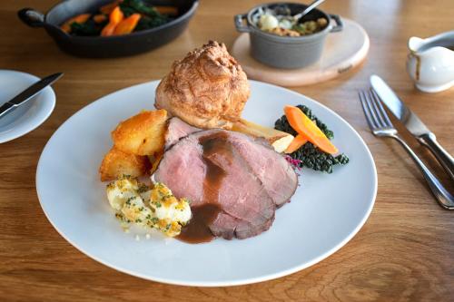 a plate of meat and vegetables on a table at Eckington Manor in Pershore
