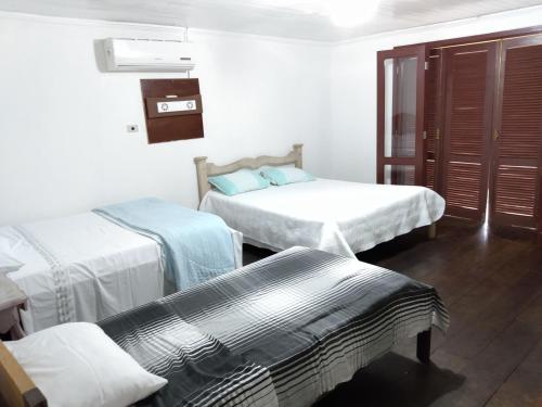 a hotel room with two beds and a window at Casa Siroba beira rio para 10 P in Morretes