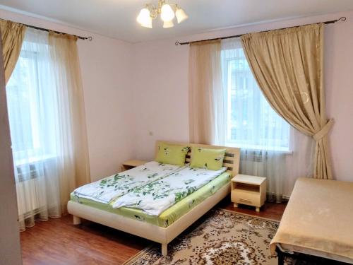 ヴィーンヌィツャにあるДвокімнатна квартира в ценрі міста на Ерусалимці поруч з фонтаном Рошенのベッドと2つの窓がある小さな寝室