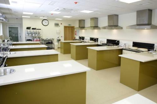 a large kitchen with many counters and a clock on the wall at Eckington Manor in Pershore