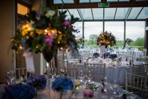 a room full of tables with chairs and flowers at Eckington Manor in Pershore