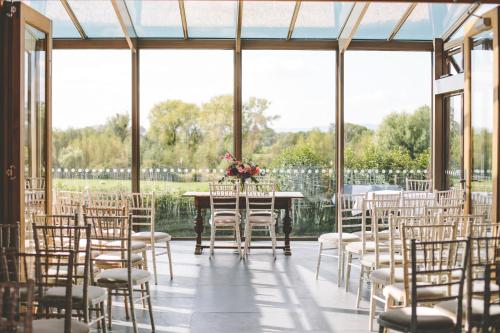 a room filled with chairs and a table with a bunch of flowers at Eckington Manor in Pershore