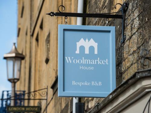 a sign for a woolmarket house hanging on a building at Woolmarket House in Chipping Campden