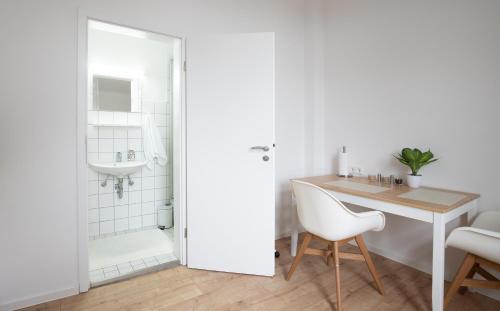 La salle de bains est pourvue d'une douche, d'une table et d'un lavabo. dans l'établissement Moderne Wohnung in der Innenstadt von Bad Oeynhausen, à Bad Oeynhausen