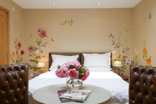 a bedroom with a bed with flowers on the wall at Eckington Manor in Pershore