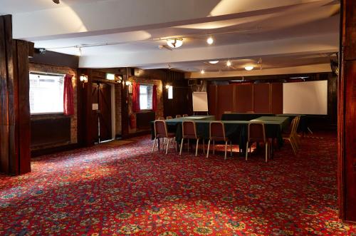 a room with a table and chairs on a red carpet at Red Lion Hotel by Greene King Inns in Fareham