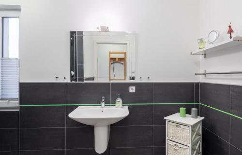 a bathroom with a sink and a mirror at Haus Calmsailing in Börgerende-Rethwisch