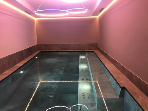 een zwembad in een kamer met roze muren bij Alpen Hotel Vidi in Madonna di Campiglio