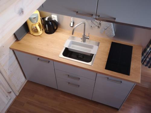 un bancone della cucina con lavello e forno a microonde di Trollveggen Camping ad Åndalsnes
