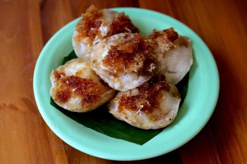 a white plate with four sugar covered donuts on a table at Samsara Desa in Kintamani
