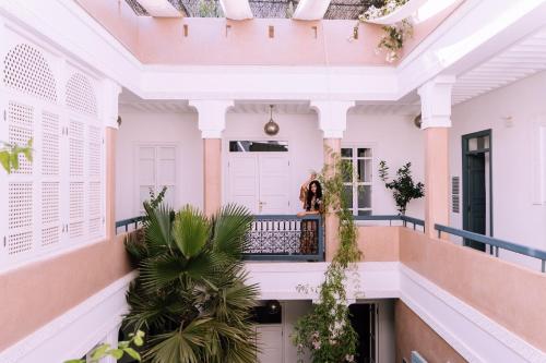 a woman standing on the balcony of a house at Riad Albatoul in Marrakesh