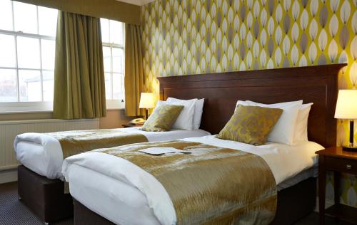 
A bed or beds in a room at King's Head Hotel By Greene King Inns
