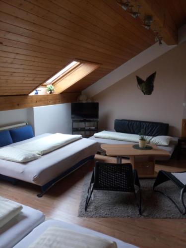 a large room with two beds and a table at Gaestehaus Kasper in Kenzingen