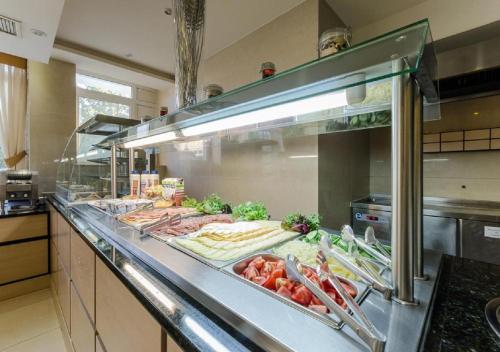 a buffet line in a kitchen with lots of food at Hotel Aurum Family "A" in Hajdúszoboszló