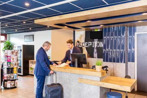 two men standing at a counter in a store at ibis budget Paris Porte d'Italie Est in Le Kremlin-Bicêtre