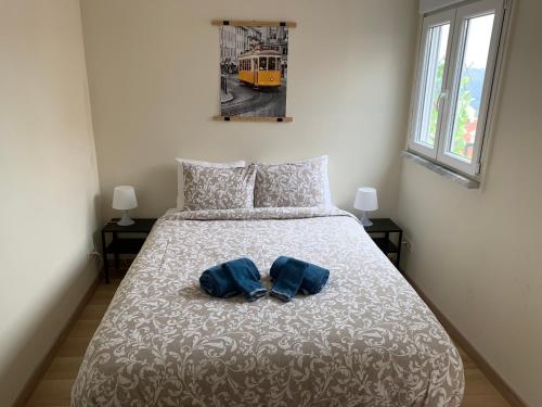 Un dormitorio con una cama con dos zapatos azules. en Apartment2 with terrace and a view near Amoreiras, en Lisboa