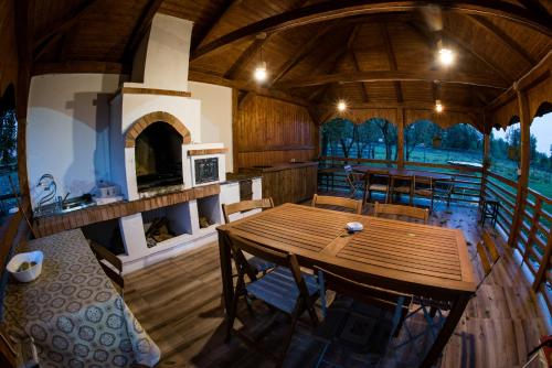 a dining room with a table and a fireplace at Casa Strabunicului in Pîrteştii de Sus