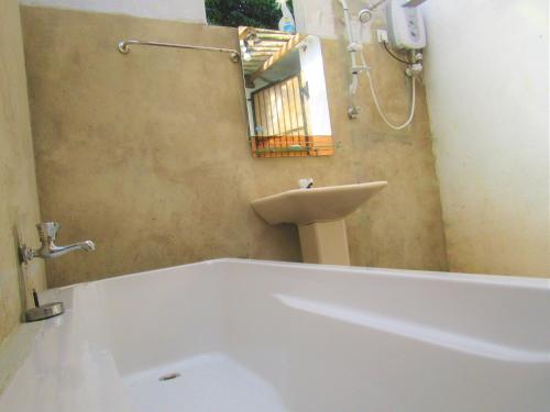 a bathroom with a bath tub and a sink at Green Herbal Ayurvedic Eco-Lodge in Galle