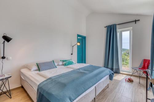 a bedroom with a large bed and a large window at Villa Vela Muline - 8 plus 2 guests - heated pool in Ugljan