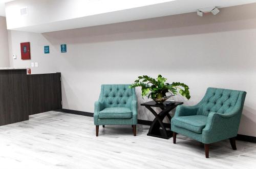 two chairs and a table in a waiting room at Express Inn in Rosenberg