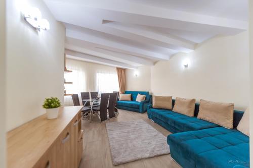 a living room with a blue couch and a table at Luxury Desing Apartment in Piteşti