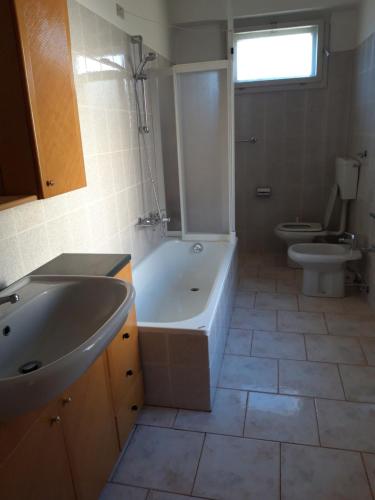 un bagno con vasca, lavandino e WC di Alla vecchia stazione a Tarvisio