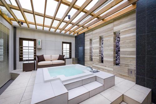 a large bathroom with a tub and a couch at HOTEL ZEN Yokohama Hazawa in Yokohama
