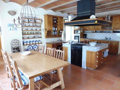cocina con mesa de madera y fogones en Belvilla by OYO Casa Lourdes en Sant Miquel de Balansat
