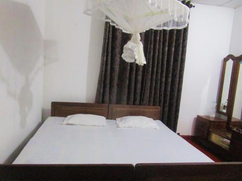 a bedroom with a bed and a window with curtains at Green Herbal Ayurvedic Eco-Lodge in Galle