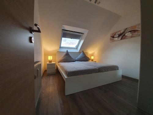 a bedroom with a bed with two pillows and a window at Haus Schneider in Winterberg