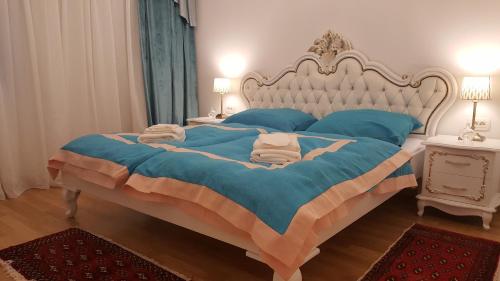 a bedroom with a large bed with blue sheets and blue pillows at E&E Apartments 4* Arena Stožice in Ljubljana