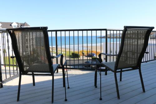 two chairs on a deck with a view of the ocean at Union Bluff Hotel & Meeting House in York Beach