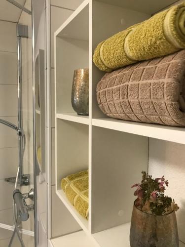 a glass cabinet with towels and vases on it at Ferienwohnung Maria in Überlingen