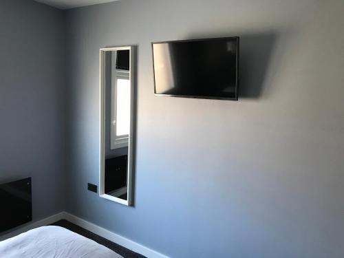 a bedroom with a flat screen tv on the wall at Cozy Rooms in Liverpool