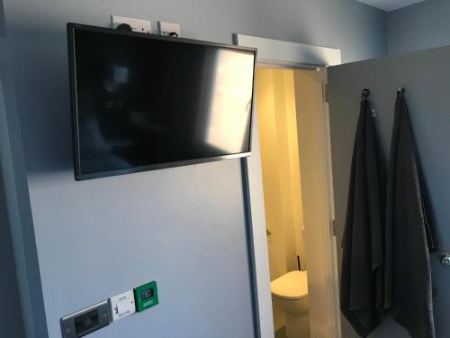 a flat screen tv on top of a refrigerator at Cozy Rooms in Liverpool