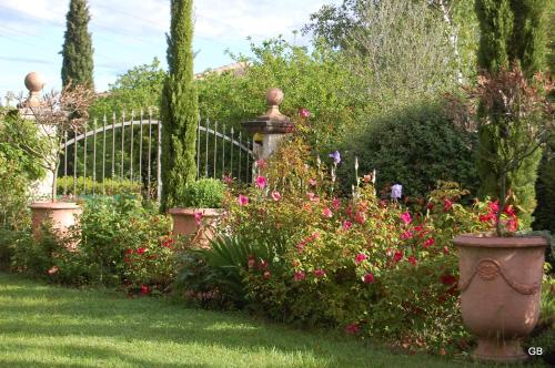 a garden with a bunch of flowers and a fence at Le GITE du MAS des CLOTS in Upie