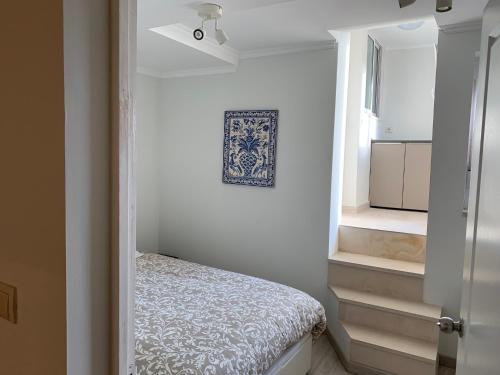 um pequeno quarto branco com uma cama e uma janela em Appartement3 avec terrasse et vue près d'Amoreiras em Lisboa