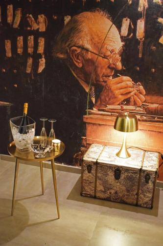 a painting of an older man sitting at a piano with a table at La Torre del Tempo in Turi