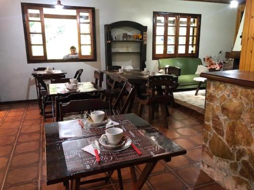 a dining room with tables and chairs and a person at Cháles Terra Nativa in Monte Verde