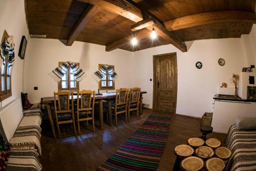 a dining room with a table and chairs at Casa Strabunicului in Pîrteştii de Sus
