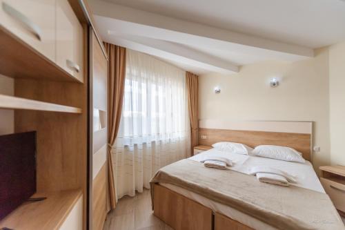 a bedroom with a bed with two towels on it at Luxury Desing Apartment in Piteşti