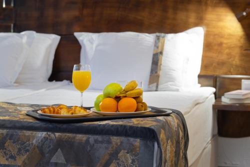 a tray of fruit and a glass of orange juice on a bed at Wine & Spa Complex Starosel in Starosel