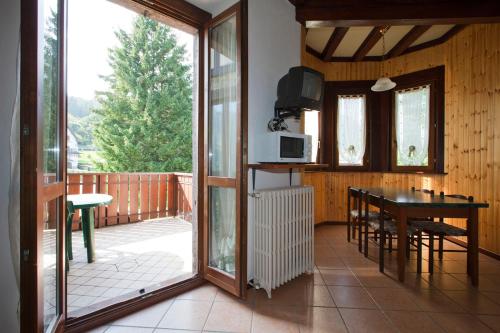 a kitchen and dining room with a balcony with a table at Villa Presolana in Castione della Presolana