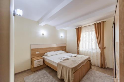 a bedroom with a bed and a window at Luxury Desing Apartment in Piteşti