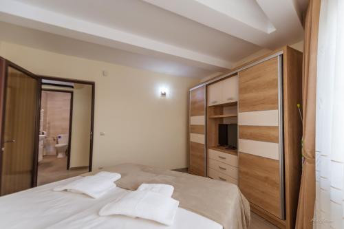 a bedroom with a bed with white sheets and pillows at Luxury Desing Apartment in Piteşti