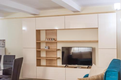 a living room with a flat screen tv and white cabinets at Luxury Desing Apartment in Piteşti