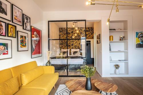 - un salon avec un canapé jaune et un lit dans l'établissement Mini loft 1 bedroom 2 steps from Av Louise, à Bruxelles